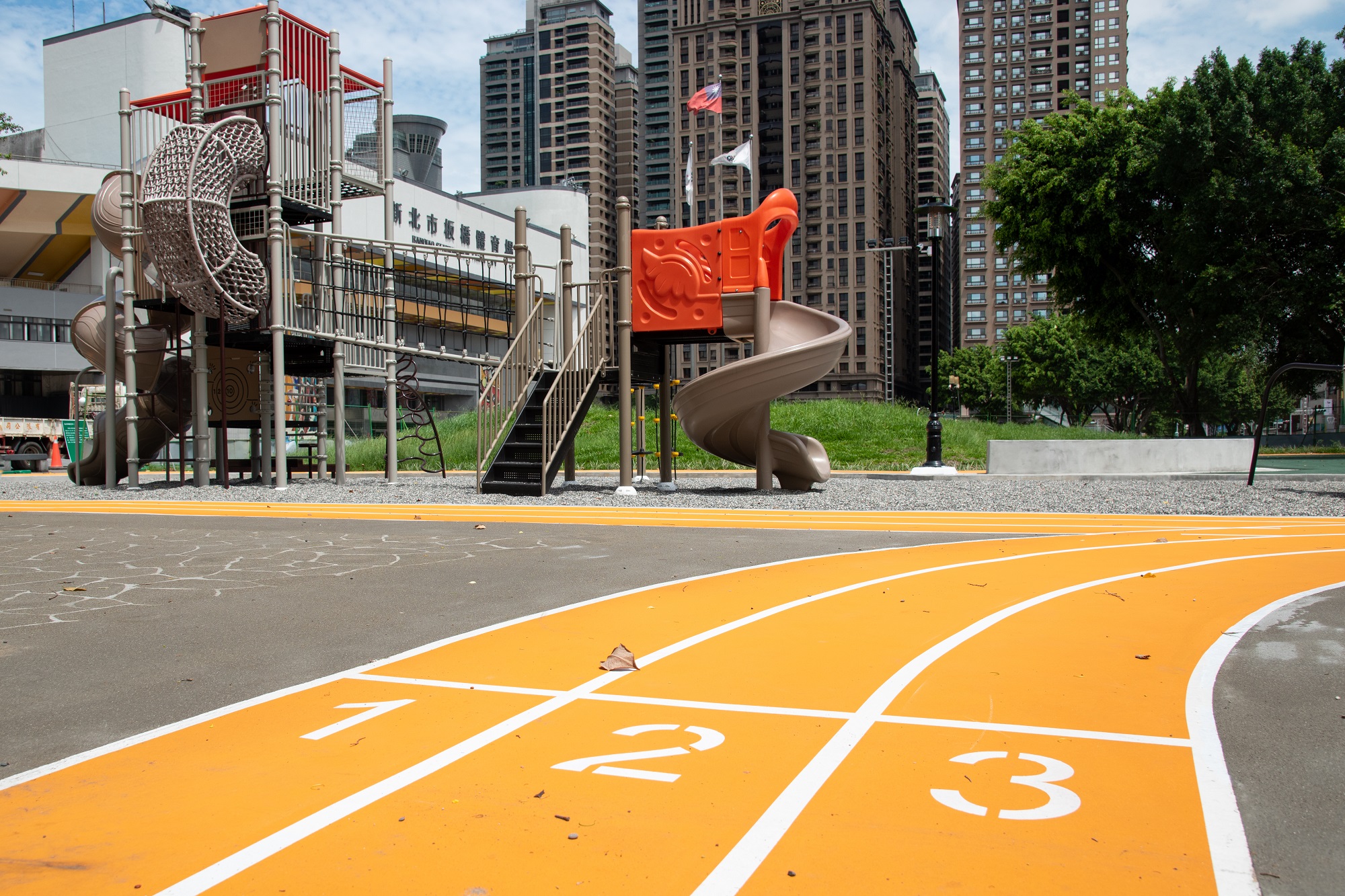 板橋第一運動場遊具緩衝區以跑道意象設置