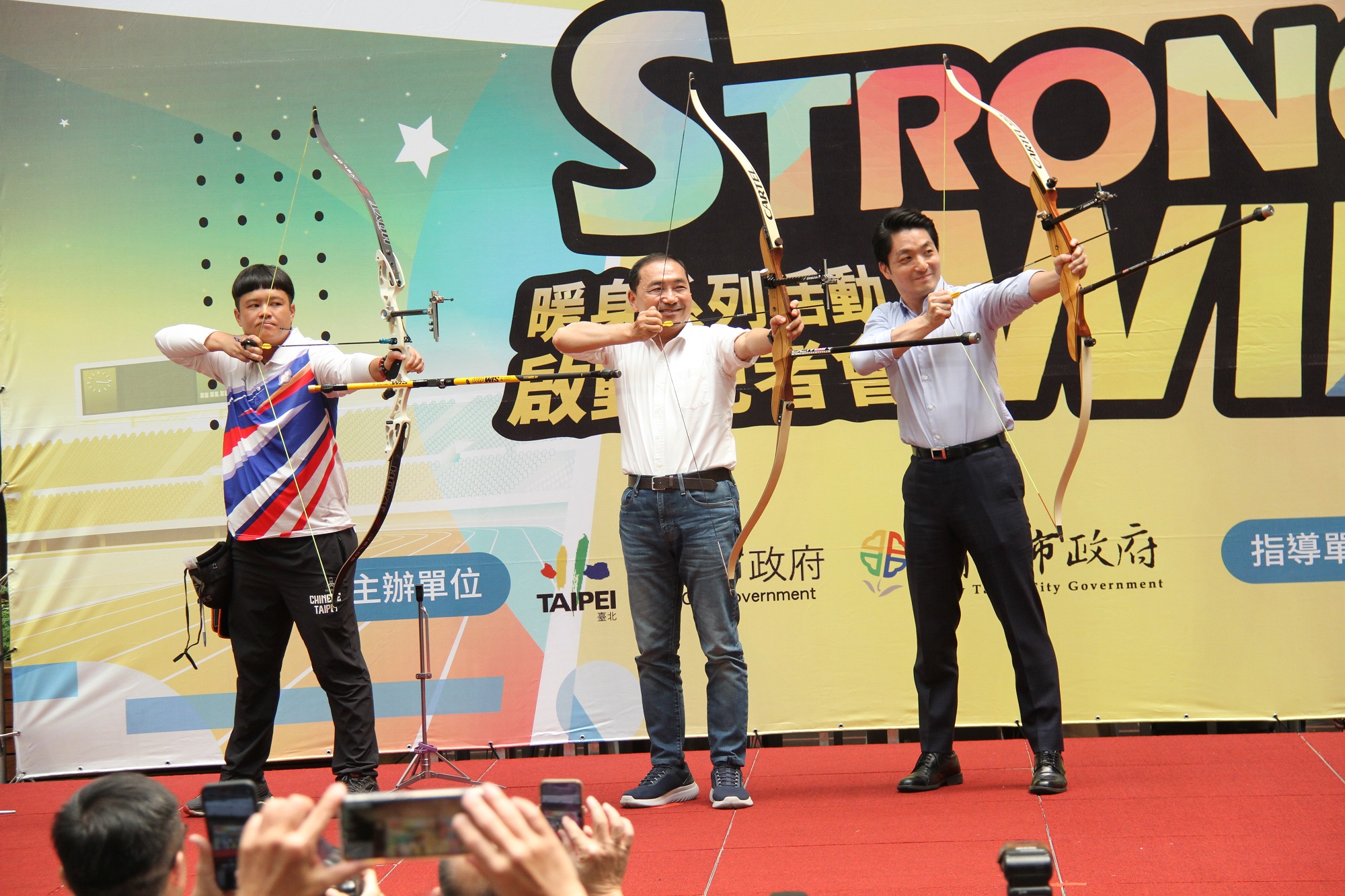 2002釜山亞運射箭金牌袁叔琪選手(左)指導臺北市長蔣萬安(右)及新北市長侯友宜(中)射箭使用方式